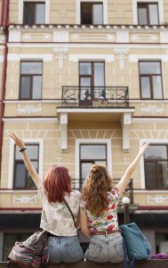 middle shot women staying facing building